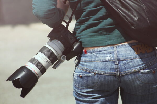 camera on woman photographer carrying camera